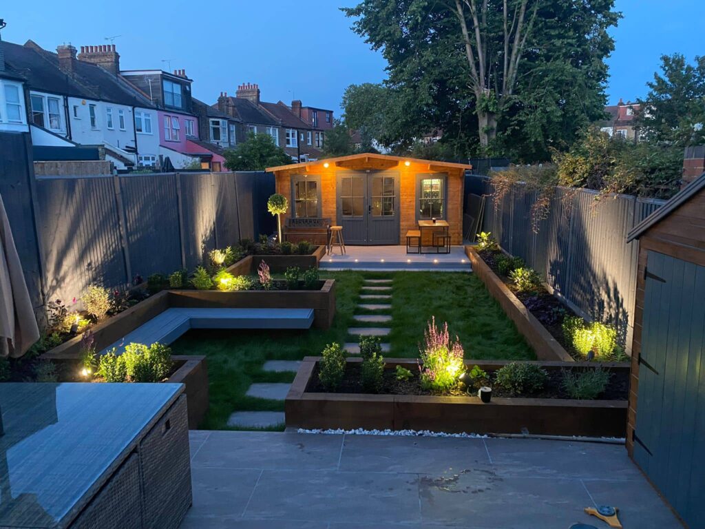 Beautiful garden featuring a charming cabin illuminated by soft lights.