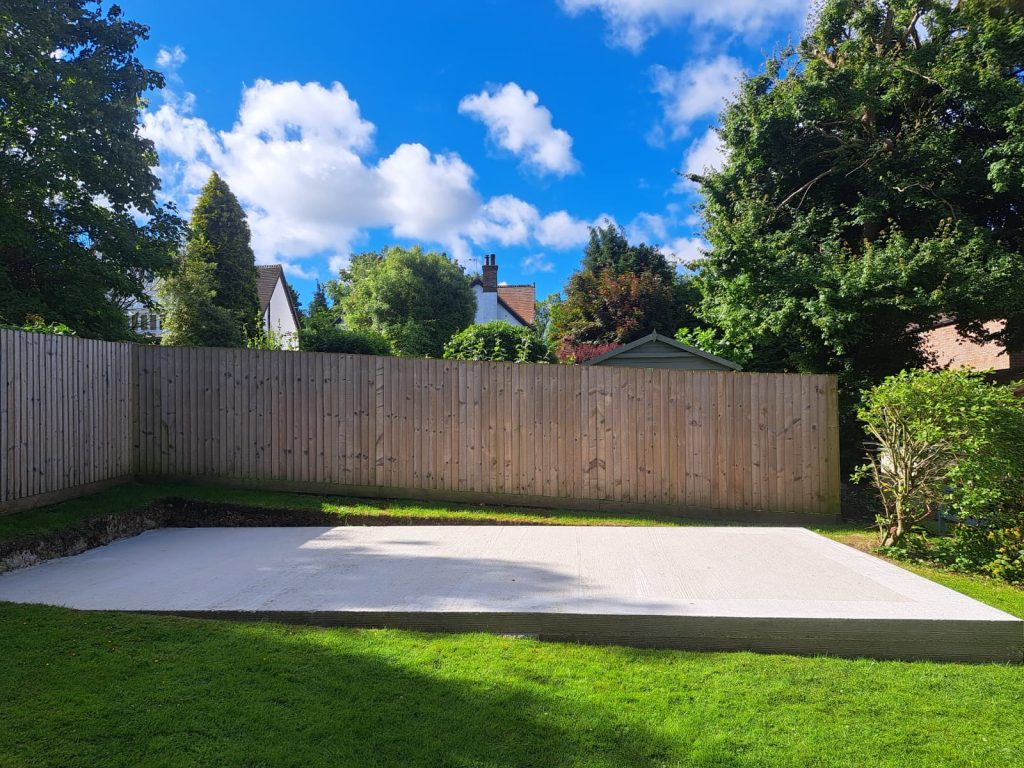 Concrete foundation in a garden, prepared for constructing a structure.