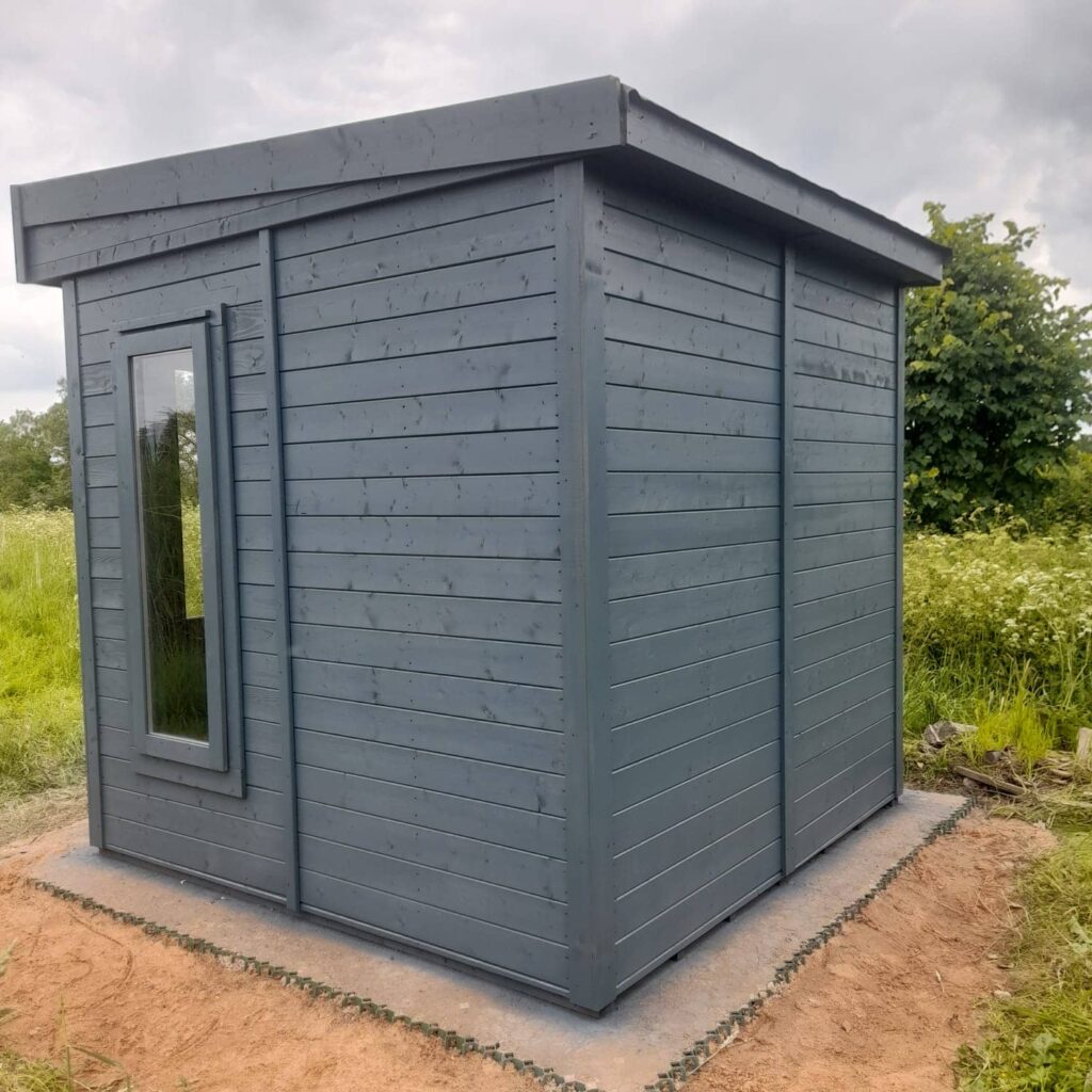 Small garden shed painted in a soft grey finish.