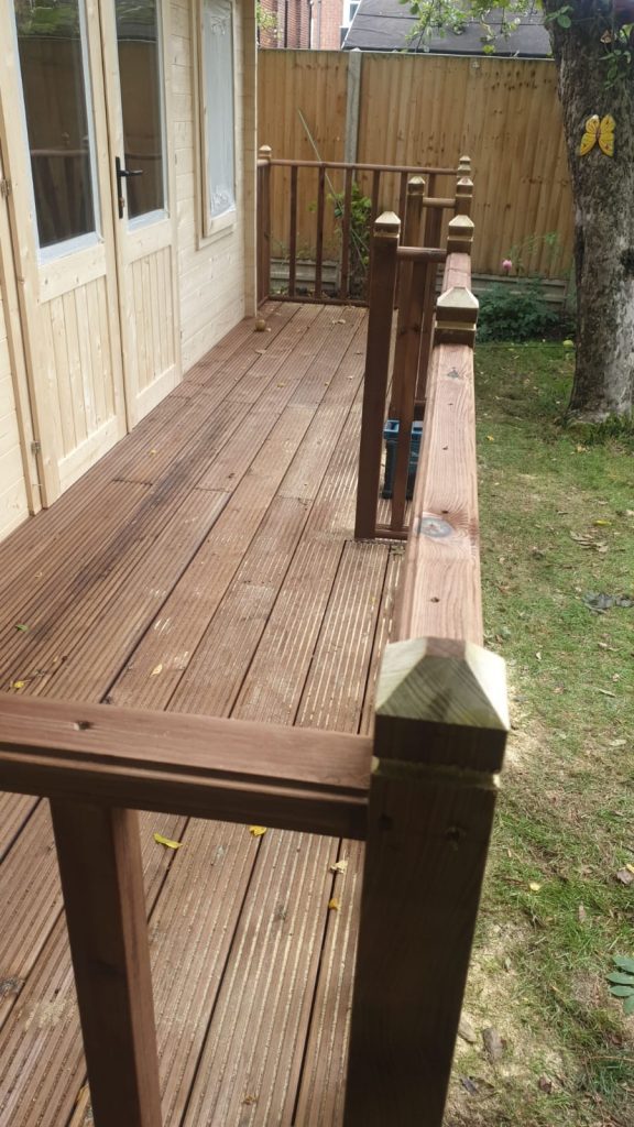Timber decking surrounding a rustic cabin.